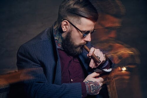 person lighting a cigar