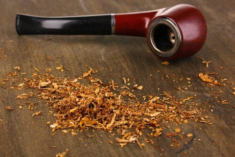 tobacco pipe laying next to pile of tobacco